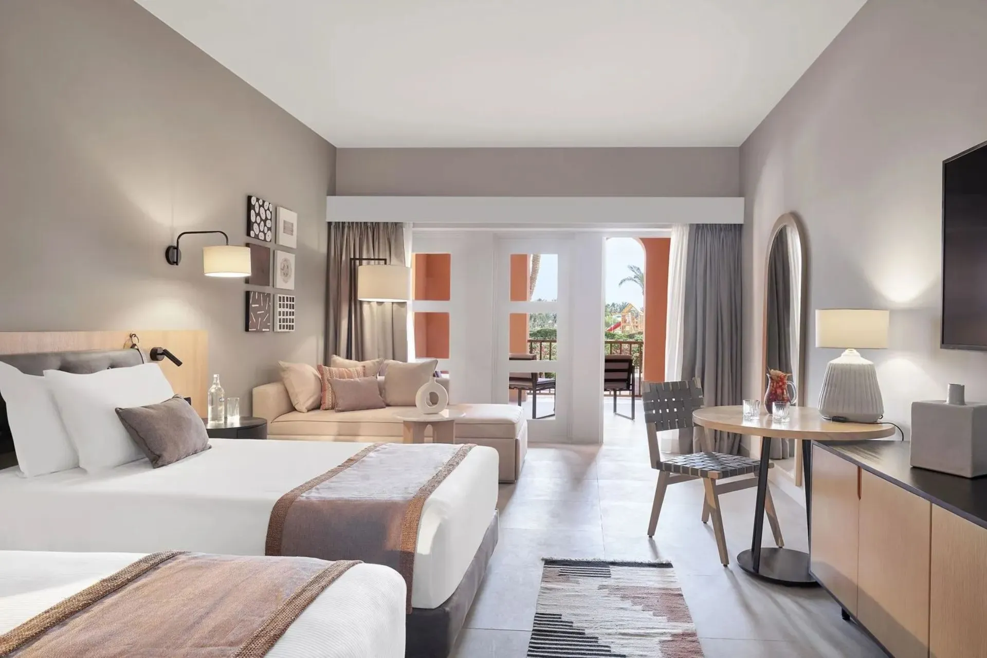 Moderne hotelkamer van Steigenberger Golf Resort El Gouna met balkon en zithoek
