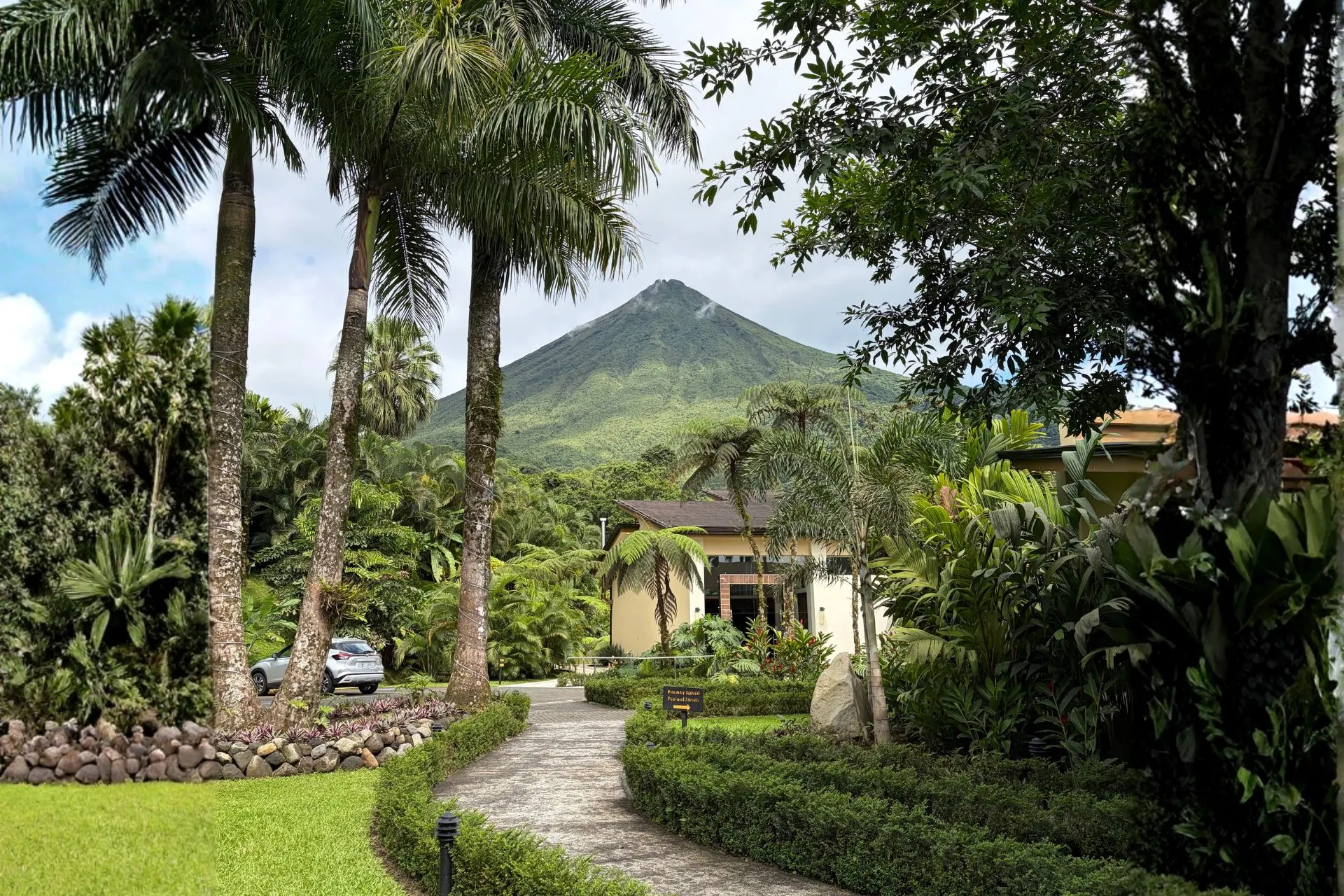 Tropische tuinen en wandelpaden bij een accommodatie in La Fortuna met uitzicht op de iconische Arenal-vulkaan. De omgeving biedt een perfecte mix van ontspanning, natuurbeleving en spectaculaire landschappen in Costa Rica.