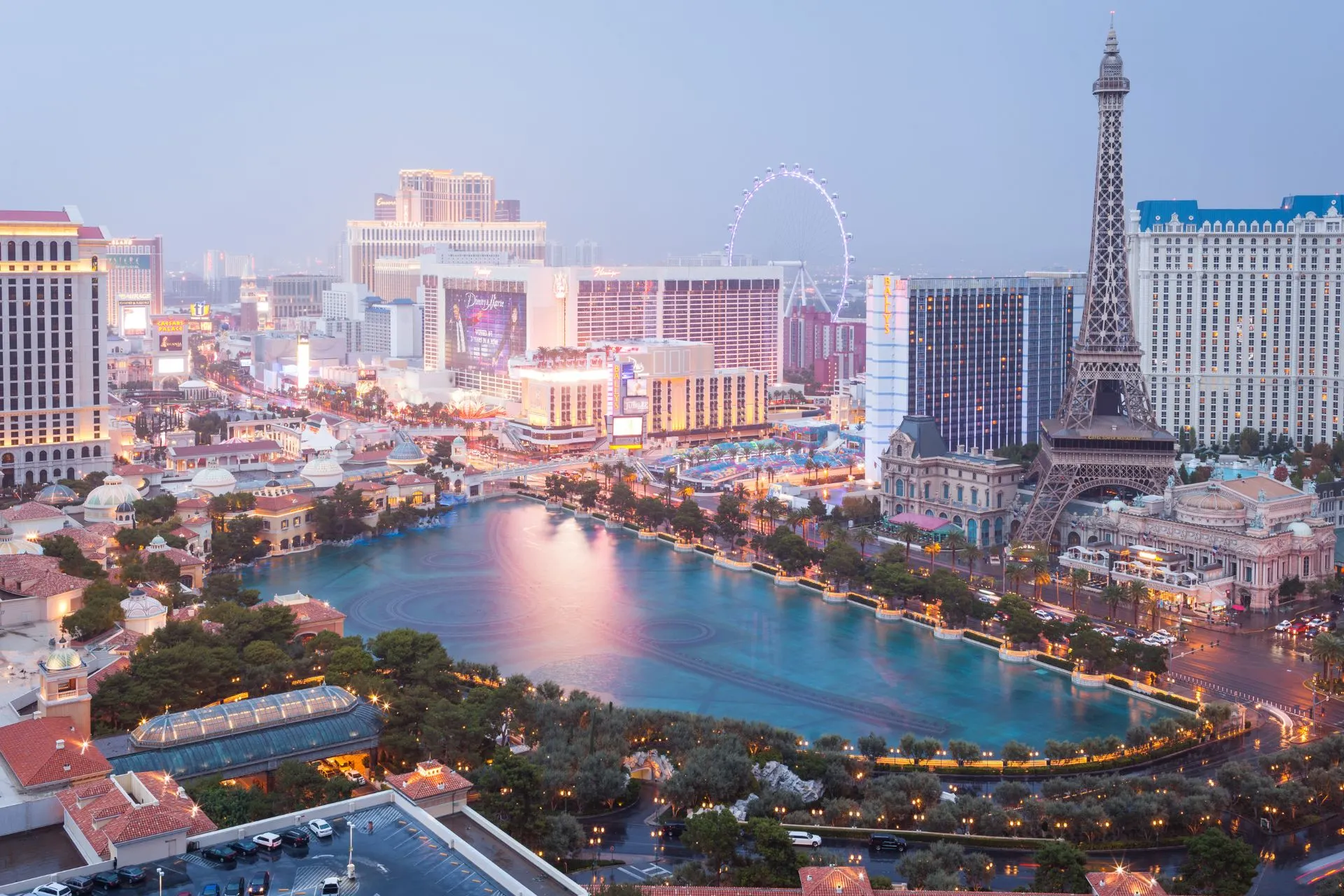 Uitzicht op de Las Vegas Strip bij avond met de Eiffeltoren, Bellagio fontein en High Roller reuzenrad in de achtergrond.