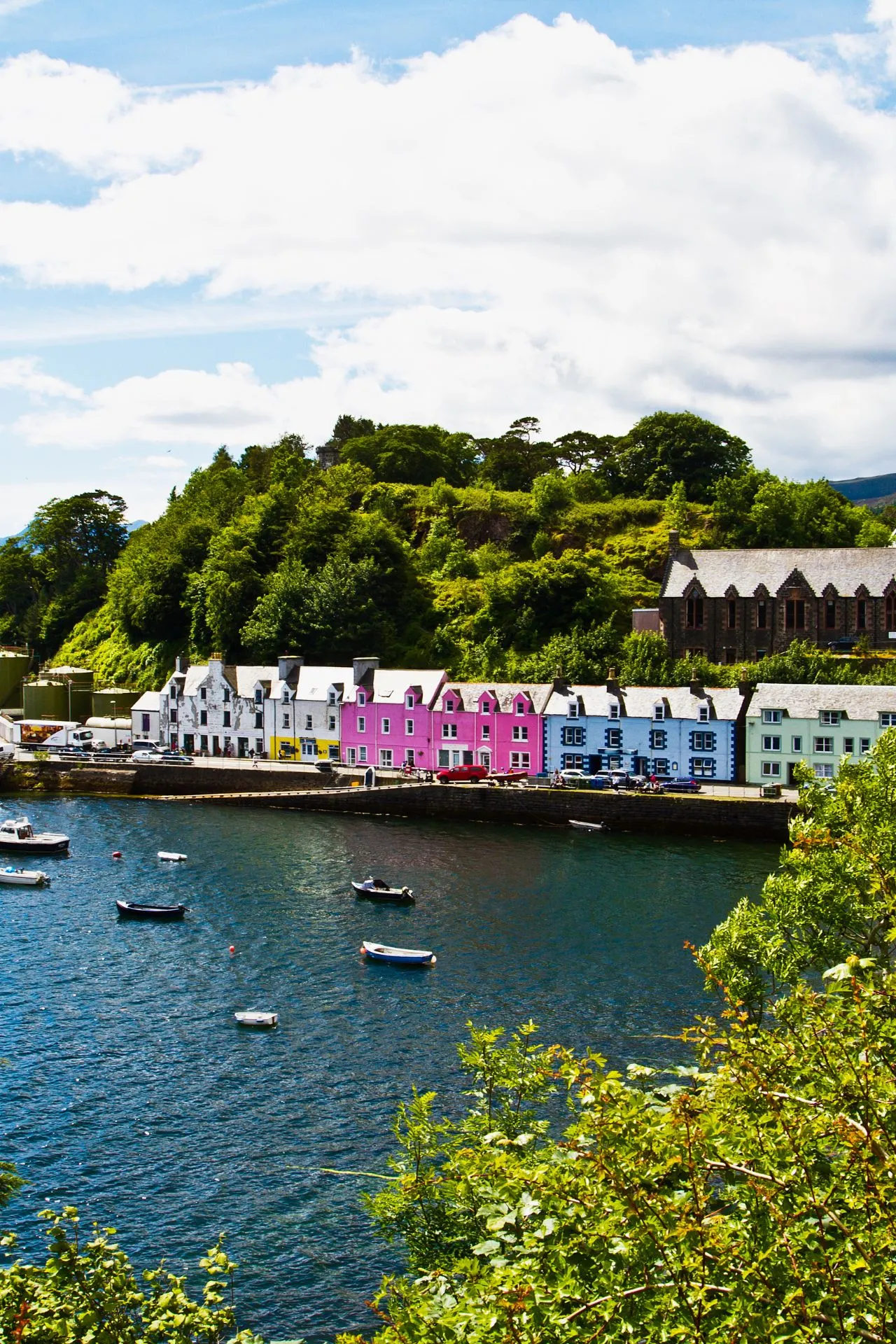"Schilderachtige haven van Portree op Isle of Skye, Schotland, met felgekleurde huizen langs het water en kleine boten dobberend in de baai. Omringd door groene heuvels en historische gebouwen, is Portree een charmante uitvalsbasis voor het verkennen van de Highlands. Ontdek authentieke Schotse cultuur, lokale gastronomie en adembenemende kustlandschappen tijdens een vakantie op Isle of Skye."


