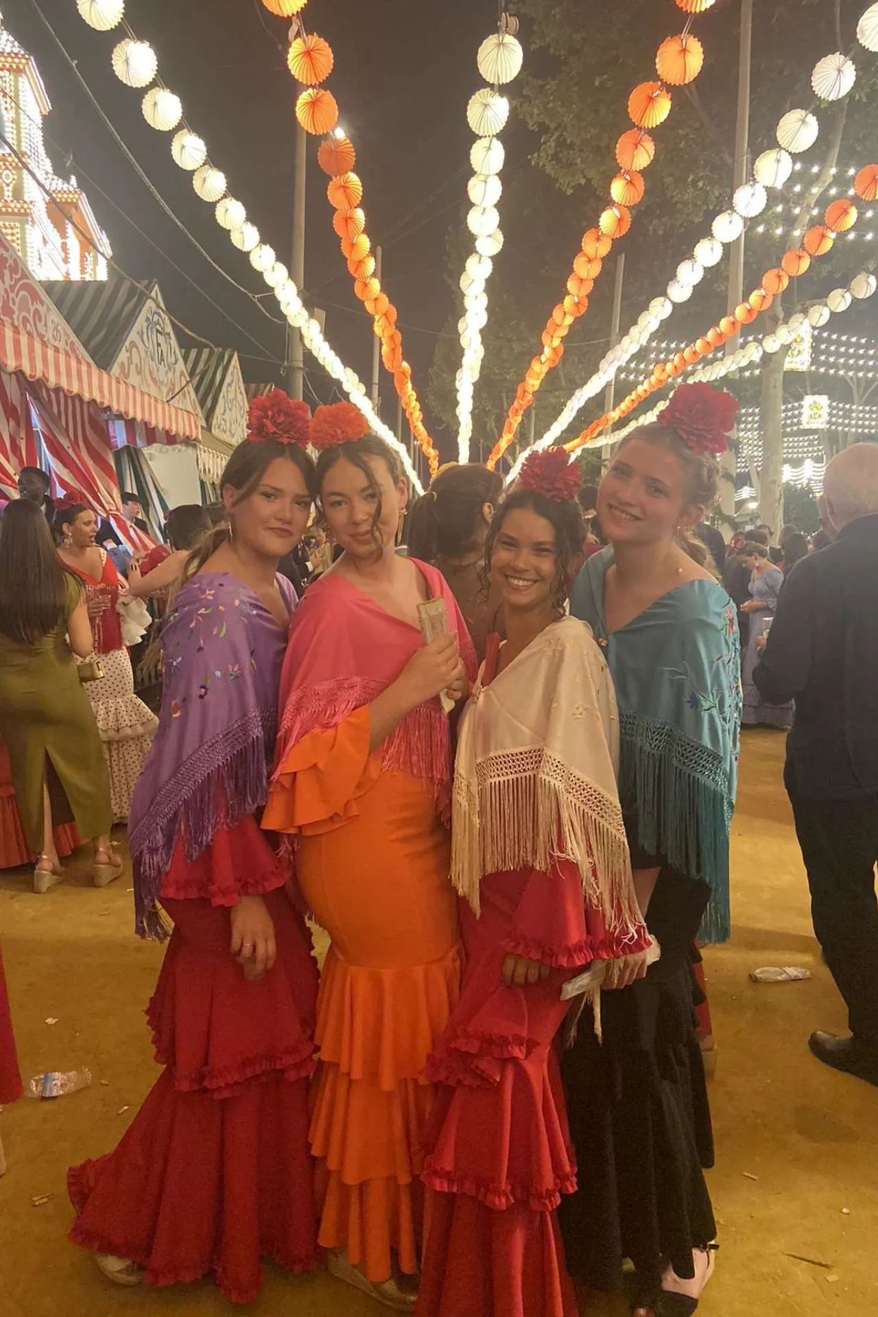 Feria de Abril in Sevilla met mensen in traditionele flamencokleding en verlichting